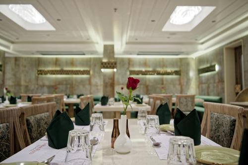 a restaurant with a table with a rose in the middle at Golden Plaza in Ahmedabad