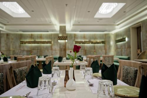 a dining room with a table with a red rose on it at Golden Plaza in Ahmedabad