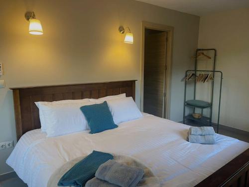 a bedroom with a large white bed with blue pillows at Casa Luna in Tolox