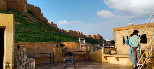 une personne debout sur un balcon donnant sur une montagne dans l'établissement The Desert Prince, à Jaisalmer