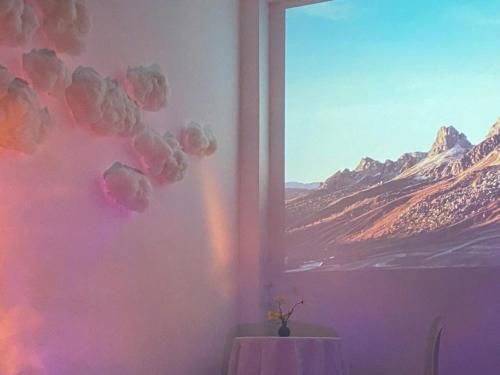 a room with a table and a view of a mountain at Cozynest Homestay n Cinema in Ho Chi Minh City
