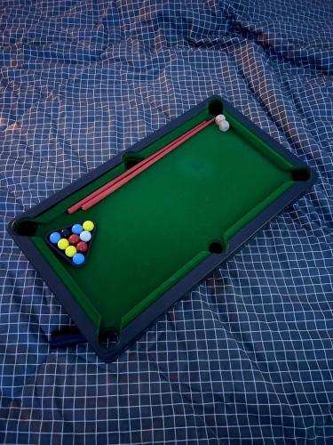 a green pool table with balls on top of a blanket at Cozynest Homestay n Cinema in Ho Chi Minh City