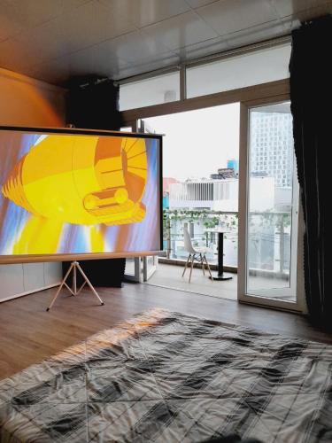 a large screen in a room with a large window at Cozynest Homestay n Cinema in Ho Chi Minh City