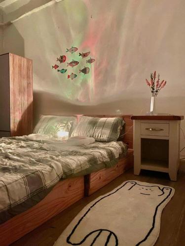 a bedroom with a bed and a table and a rug at Cozynest Homestay n Cinema in Ho Chi Minh City