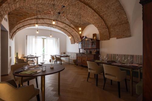 a dining room with tables and chairs and a large ceiling at Boutiquehotel Zum Goldenen Hirschen in Gmunden