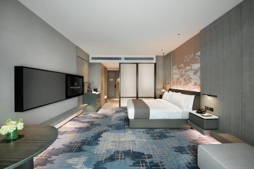 a hotel room with a bed and a flat screen tv at 开芯国际大酒店 in Guangzhou