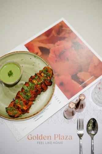 a plate with a piece of food on a table at Golden Plaza in Ahmedabad