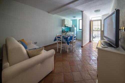 a living room with a couch and a tv and a kitchen at Casa Spiga in Cagliari