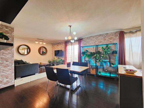 a dining room and living room with a table and chairs at Cocoon'Inn Blagnac in Blagnac