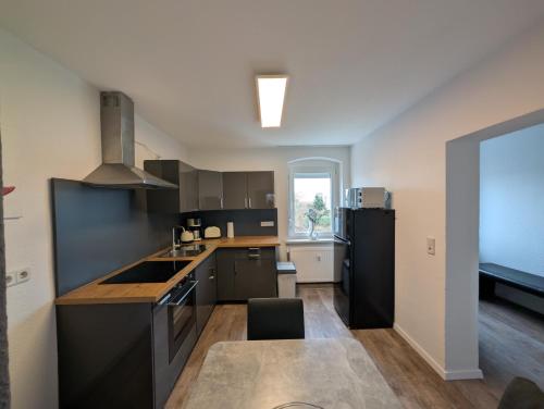 a kitchen with black cabinets and a black refrigerator at Richter Apartments Finsterwalde mit Klimaanlage in Finsterwalde