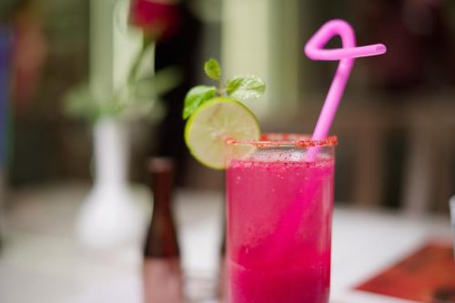 a pink drink with a lime on a table at Golden Plaza in Ahmedabad