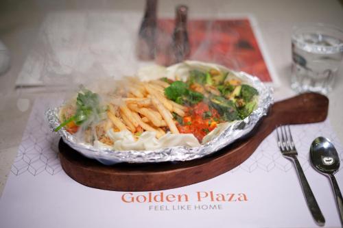 a plate of food with pasta and vegetables on a table at Golden Plaza in Ahmedabad