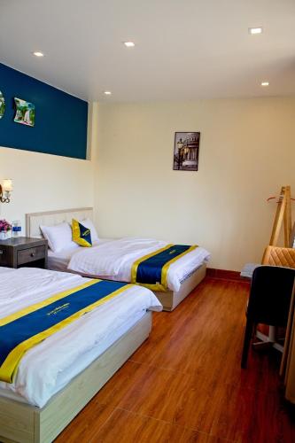 a hotel room with two beds and a chair at Blue Diamond Homestay - Lake View Standar in Ấp Bình Phú