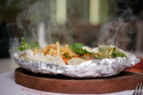 a bowl of food with french fries and smoke at Golden Plaza in Ahmedabad