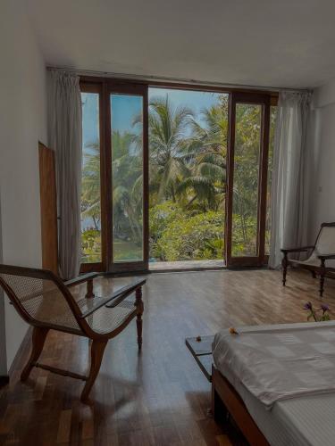 a bedroom with a bed and a large window at Red Mangrove in Bentota