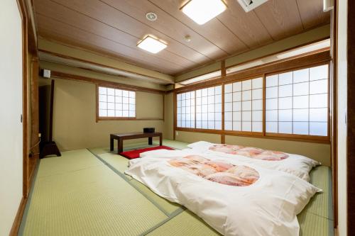 Postel nebo postele na pokoji v ubytování Hotel Matsumoto Yorozuya
