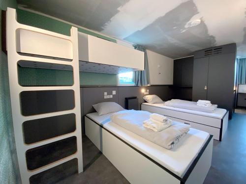 a room with two beds and a bunk bed at HOME Hostel im Schönhof-Viertel in Frankfurt/Main