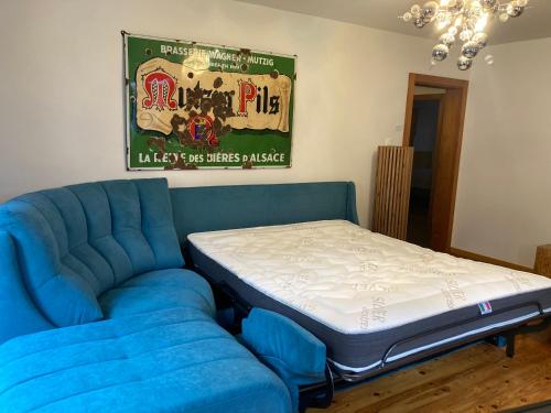 a bed sitting next to a blue couch with a mattress at Le P'retzel & Le Sticksy in Riquewihr