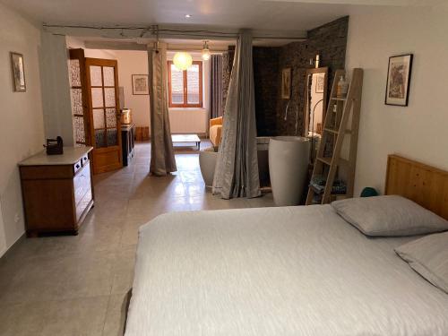 a bedroom with a bed and a living room at Le P'retzel & Le Sticksy in Riquewihr