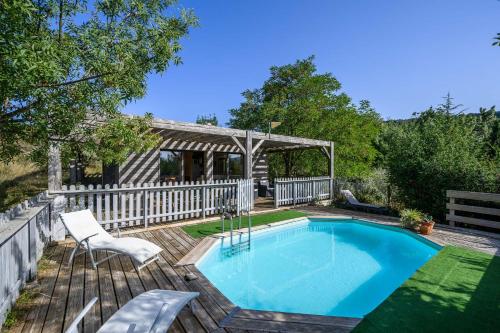 - une piscine sur une terrasse en bois avec une clôture blanche dans l'établissement Maison - piscine - Vue vignobles coeur de nature, à Roquetaillade