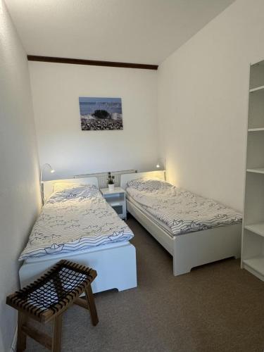 a room with two beds and a bench in it at 12 Ferienwohnung Familienzeit in Burg auf Fehmarn