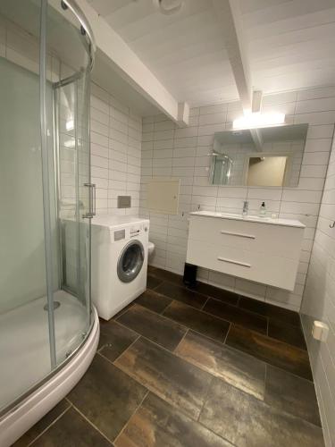 a bathroom with a washing machine and a sink at Dronningens Gate 95, 0402 Kristiansand in Kristiansand
