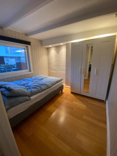 a small bedroom with a bed and a window at Dronningens Gate 95, 0402 Kristiansand in Kristiansand