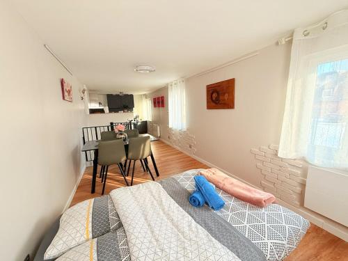 a bedroom with a bed and a dining room at Duplex Fleckenstein - Centre Historique de Haguenau in Haguenau