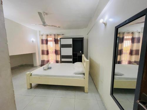 a small bedroom with a bed and a mirror at 2 bedroom apt 323 Kisimani Heights, Mombasa, Kisimani in Mombasa
