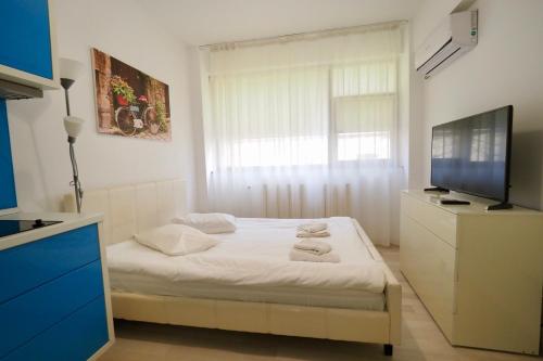 a small bedroom with a bed and a television at Iassium Residence Iasi in Iaşi