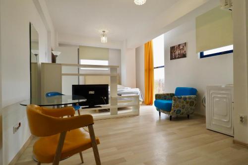 a living room with a table and chairs and a bed at Iassium Residence Iasi in Iaşi