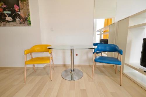 a table and three chairs in a room at Iassium Residence Iasi in Iaşi