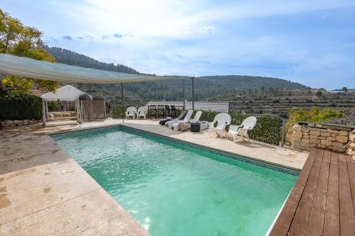 a swimming pool with chairs and a view of a mountain at עיינות ספיר - Einot Sapir in Sappir
