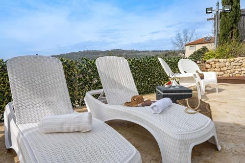 a group of white chairs sitting on a patio at עיינות ספיר - Einot Sapir in Sappir