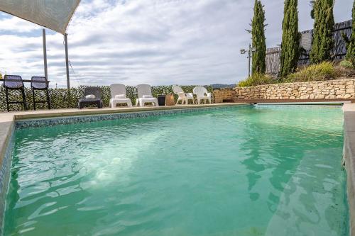 a swimming pool with a group of chairs next to it at עיינות ספיר - Einot Sapir in Sappir