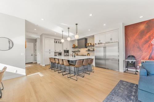 a kitchen and living room with a large island with bar stools at Slickrock Shore townhouse in St. George