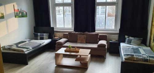 a living room with a couch and a bed at Richter Apartments Finsterwalde mit Klimaanlage in Finsterwalde