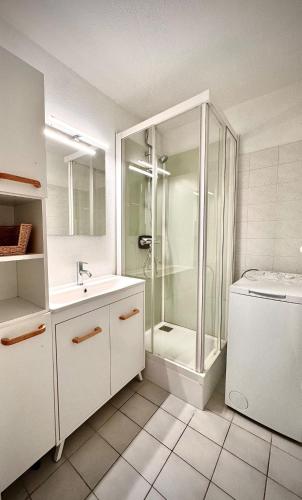 a white bathroom with a shower and a sink at Apartment Cosy - Lake View in Le Grau-du-Roi