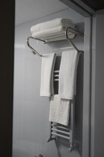 a group of towels hanging on a rack in a bathroom at New Hotel Harbiye in Istanbul