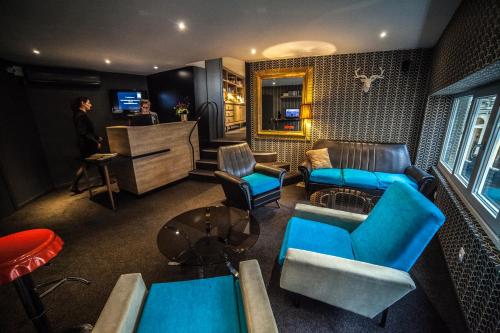 - un salon avec des fauteuils bleus et un canapé dans l'établissement Hotel Kanaï, à Lille