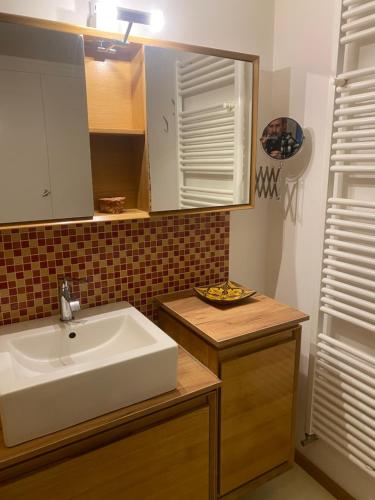 a bathroom with a sink and a mirror at Maison verte in Roche