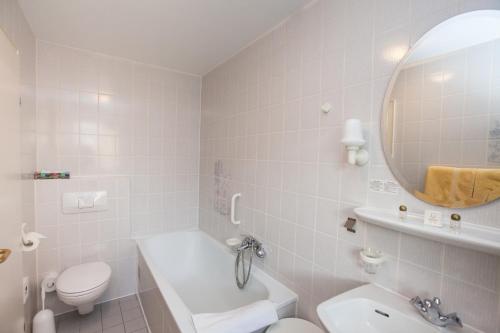 a bathroom with a sink toilet and a mirror at Hotel Garni Günther in Boppard