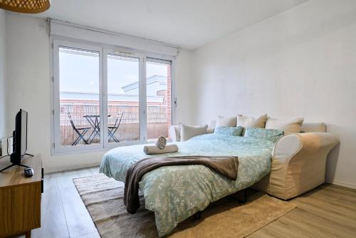 une chambre avec un lit et une grande fenêtre dans l'établissement Élégant appartement avec balcon privé à Lille, à Lille