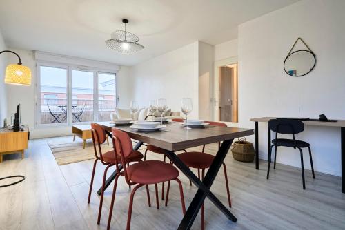 une salle à manger et un salon avec une table et des chaises dans l'établissement Élégant appartement avec balcon privé à Lille, à Lille
