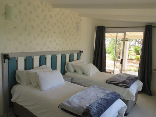 a bedroom with two beds and a window at Tropic of Capricorn Guest Farm in Rehoboth