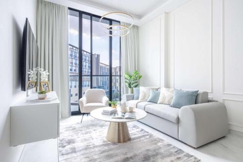 a living room with a couch and a table at Frank Porter - Samana Park Views in Dubai