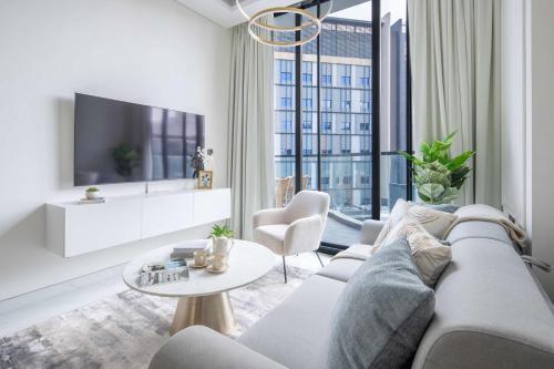 a living room with a couch and a tv at Frank Porter - Samana Park Views in Dubai