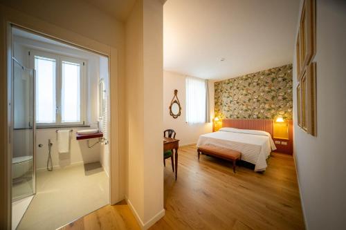 ラヴェンナにあるAlbergo del Cuoreのベッドとバスルームのある寝室