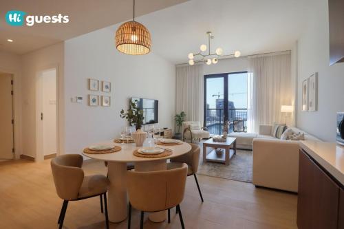 a dining room and living room with a table and chairs at HiGuests - Elegant 1BR Retreat with Sea View in La Rive in Dubai