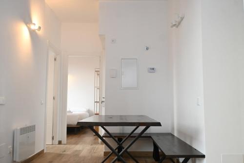 a black table in a white room with a bed at Homenfun Dalt Badalona in Badalona